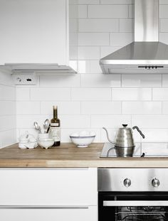 a stove top oven sitting inside of a kitchen next to a counter with pots and pans on it