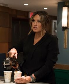 a woman pouring coffee into two cups