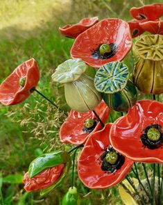 an arrangement of red and green ceramic flowers