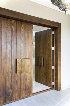 an open wooden door in front of a white wall