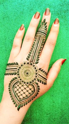 a woman's hand with henna tattoos on it