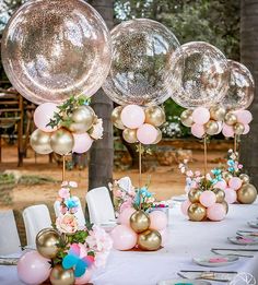 a table topped with lots of balloons and flowers