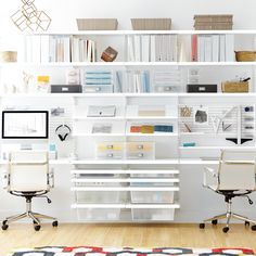 a white desk with two chairs and a computer monitor on it in front of a bookshelf