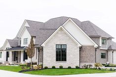 a large white brick house with lots of windows and green grass in the front yard