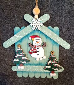 a christmas ornament with a snowman in a house on it's side