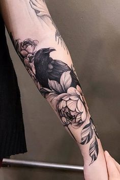 a person with a black bird tattoo on their arm