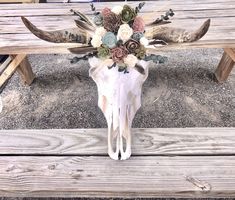 an animal skull with flowers on it is sitting on a bench