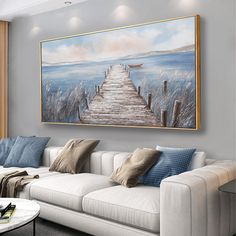 a living room with a white couch and painting on the wall