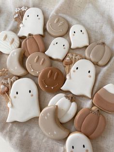 cookies decorated with different shapes and designs on a table cloth, including ghost faces and pumpkins