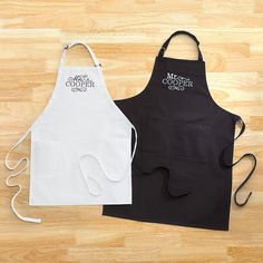 two aprons are sitting on the floor next to each other, one is black and white