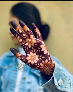 a close up of a person's hand with hennap and flowers on it