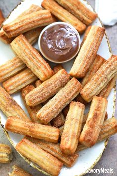 fried churros on a plate with dipping sauce