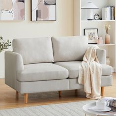 a living room with a couch, coffee table and pictures on the wall