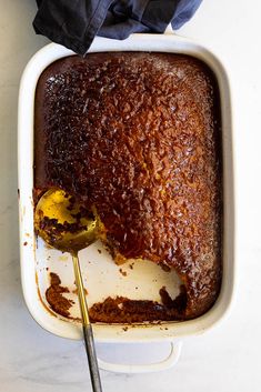 a cake in a baking dish with a spoon