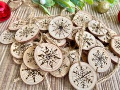 wooden ornaments with snowflakes on them sitting on a table next to christmas decorations