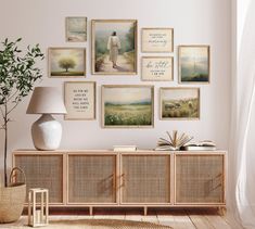 a living room with pictures on the wall and a lamp in front of it next to a book shelf