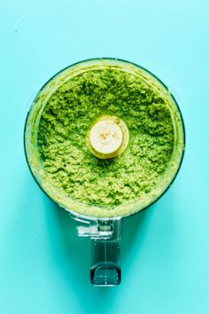 a blender filled with green liquid on top of a blue surface