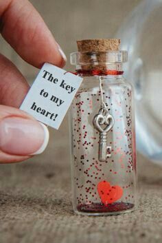 someone is holding a key to their heart in a glass bottle with a tag on it