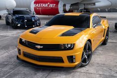 the yellow car is parked in front of an airplane