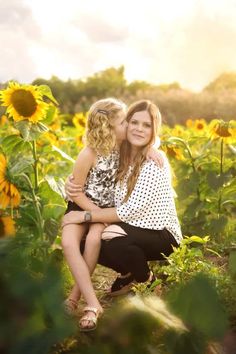 mother and daughter hugging in sunflower field