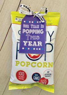 a bag of pop corn sitting on top of a wooden floor next to a sign