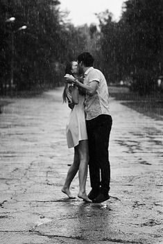 a man and woman kissing in the rain