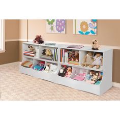 a white bookcase filled with lots of books on top of a carpeted floor