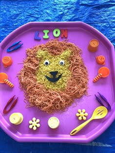 a purple tray with an animal made out of noodles and plastic utensils on it