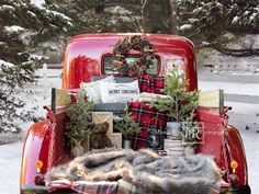 an old red truck with christmas decorations in the back