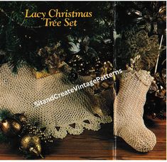 an old fashioned lace christmas tree set with stockings and ornaments on the floor next to it