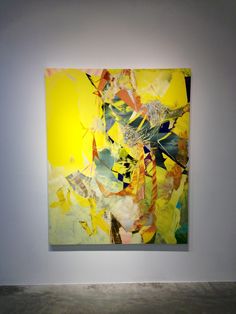 an abstract painting on display in a white room