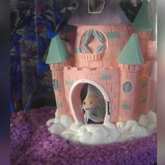 there is a cake made to look like a castle with a cat in the window