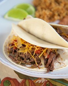 two tortillas filled with shredded meat and cheese on top of a white plate