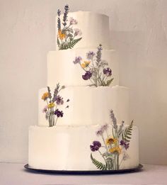 a three tiered cake with flowers painted on it