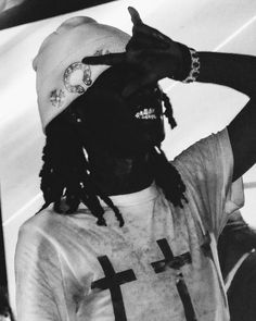 a black and white photo of a man with dreadlocks wearing a t - shirt