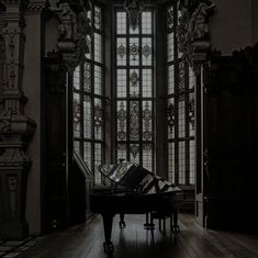 a grand piano sitting in front of a large window