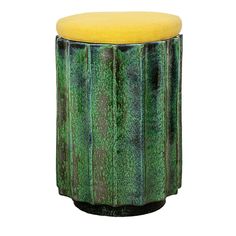 a green and yellow stool sitting on top of a white floor