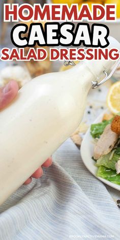 homemade caesar salad dressing being drizzled on a plate with lemon wedges