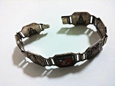 1930s Art Deco bracelet depicting iconic Parisian landmarks. In good condition, with some enamel loss, wear, and tarnish. Antique Enamel Bracelet Collectible, Paris Souvenirs, Art Deco Bracelet, 1930s Art Deco, Antique Metal, Casio Watch, Vintage Sterling Silver, Mens Bracelet, Favorite Jewelry