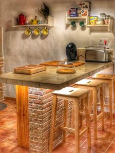 a kitchen with several stools and a counter in front of some shelves on the wall