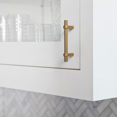 a close up of a door handle on a white cabinet with gold handles and knobs