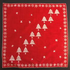 a red bandana with white snowflakes and trees on it