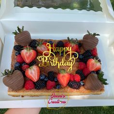 a birthday cake with strawberries and chocolate covered strawberries