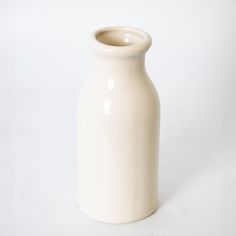 a white vase sitting on top of a table