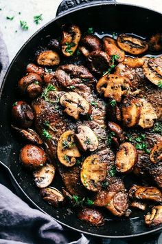 a skillet filled with mushrooms on top of a table