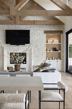 a living room filled with furniture and a flat screen tv mounted on the wall above a fireplace