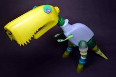 a yellow plastic toy with a green and blue bottle attached to it's head