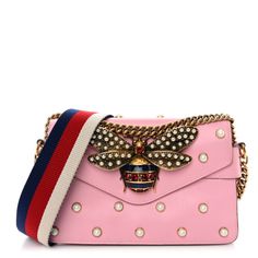 This is an authentic GUCCI Nappa Pearl Studded Mini Queen Margaret Broadway Shoulder Bag in Sugar Pink.This shoulder bagis crafted of smooth and supple pink calfskin leather with faux pearl studs decorated throughout. The bag features is an aged gold chain-linkshoulder strap with an optional white, red, and blue canvas web shoulder strap. The front flap has a large decorative aged gold bee embellished with faux pearls and ruby red gems with dark blue resin. This opens to an expandable beige leat Luxury Pink Bag With Pearl Handle, Rectangular Leather Bag With Pearl Handle, Leather Shoulder Bag With Pearl Handle, Queen Margaret, Red Gems, Gucci Crossbody Bag, Gucci Crossbody, Gucci Shoulder Bag, Bag Light