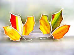 three stained glass flowers sitting on top of a window sill