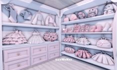 a closet filled with lots of pink and white baby clothes on shelves next to drawers